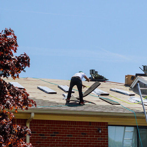 workers on a shingle roof